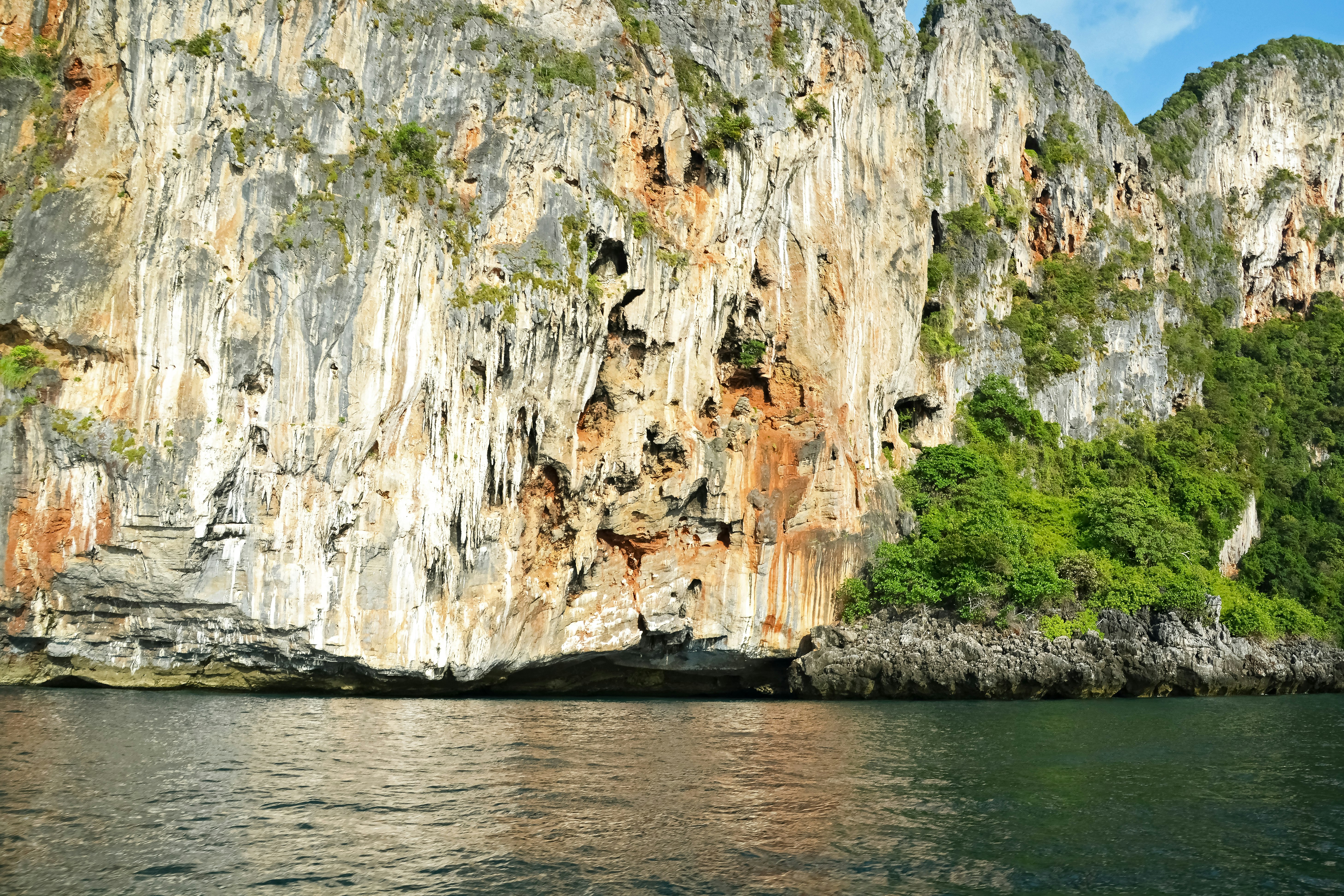 brown and white rock formation on body of water during daytime